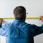 man measuring wall with measuring tape 53876 63283